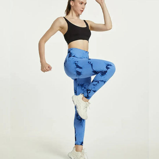 femme fait des exercice de jambe avec ses leggings bleu